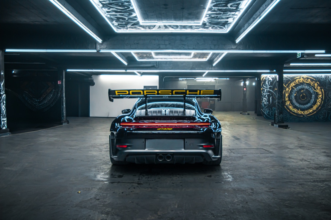 Porsche 911 GT3 RS von hinten mit Heckflügel in einer Halle mit LED-Deckenrahmen