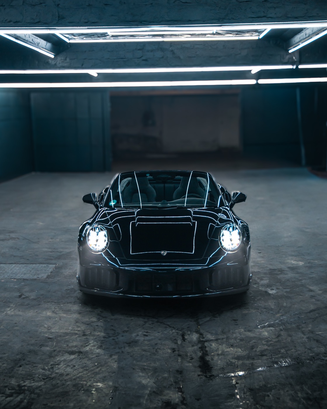 Porsche 911 Turbo S Cabriolet frontal mit geöffnetem Verdeck und eingeschalteten Scheinwerfern